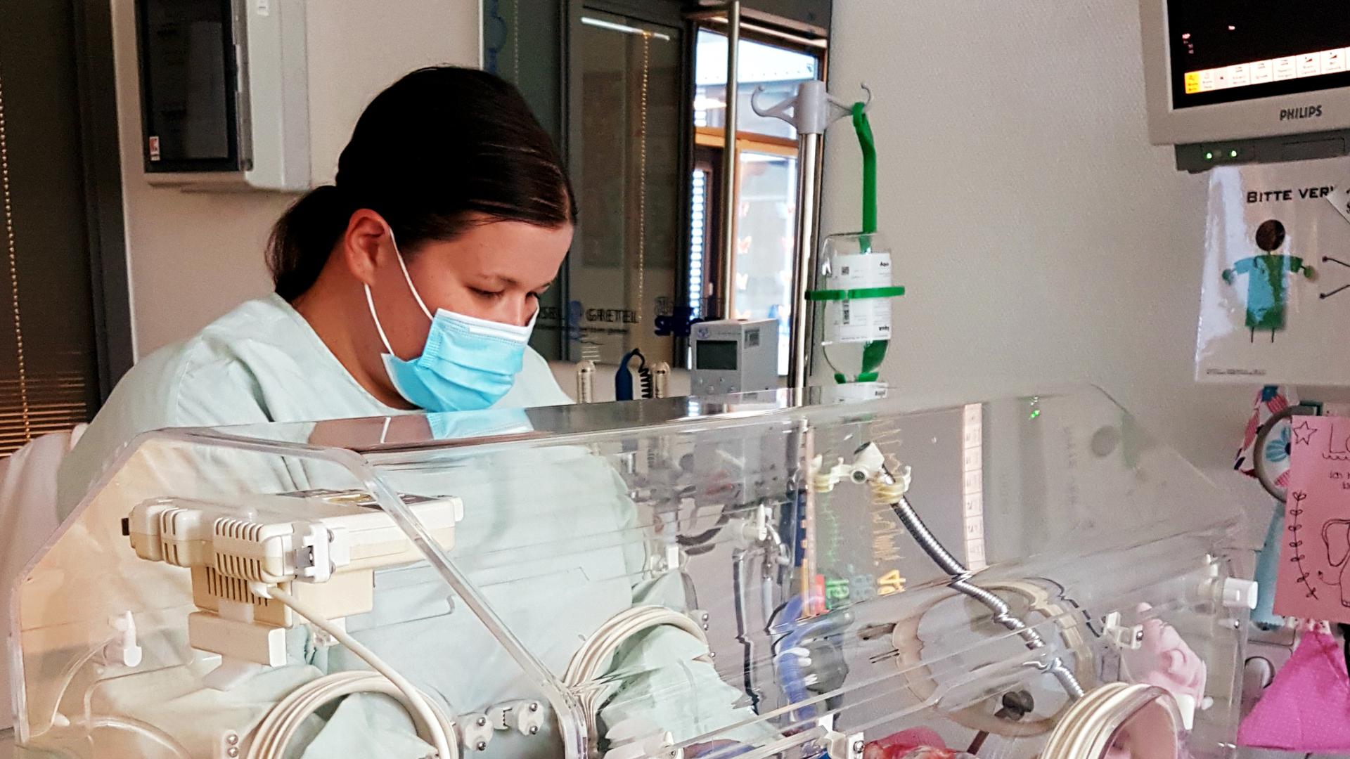 Frau steht an Baby Inkubator