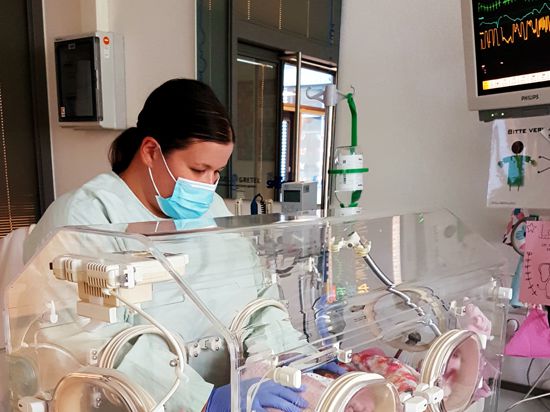 Frau steht an Baby Inkubator
