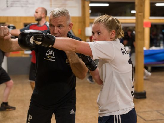 Trainer Christian Richter erklärt Redakteurin Marie Orphal die richtige Armhaltung beim Boxen.