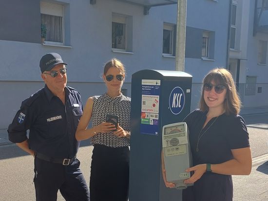 Ordnungsamtsleiterin Jessica Deutsch mit Nina Schüßler und Steffen Schmidt vom städtischen Ordnungsamt stehen vor einem Parkautomaten.