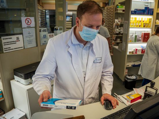 Apotheker Ernst Ciupka in der Bruchsaler Hirschapotheke mit einem Grippeimpfstoff