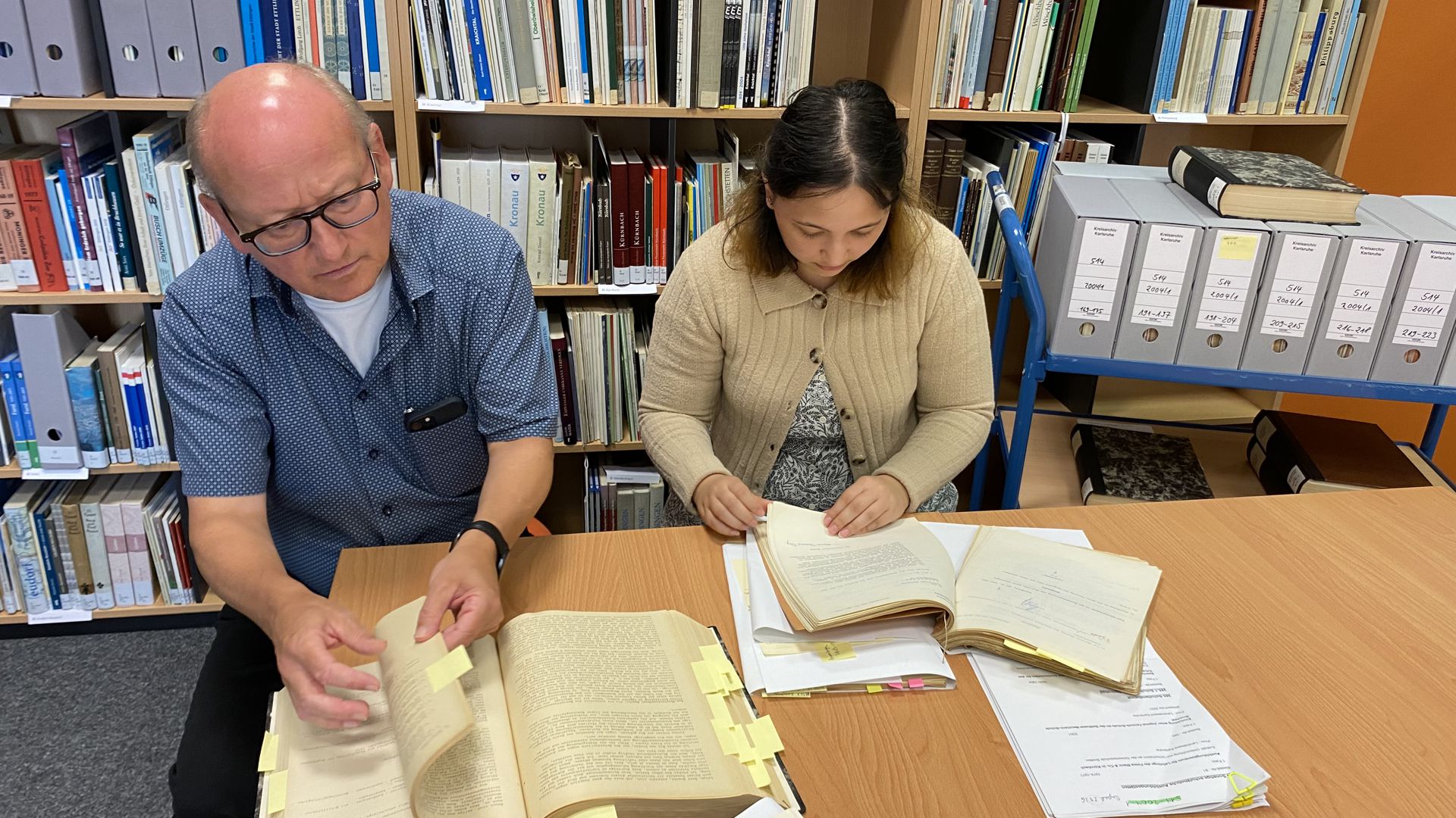 Kreisarchivar Bernd Breitkopf und Studentin Katharina Schulz recherchieren in den Unterlagen zum ehemaligen Schullandheim Steinabad.