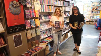 Heike Braunbarth und Elena Gillhausen (von links) zeigen den Bereich mit den BookTok-Bestseller-Büchern