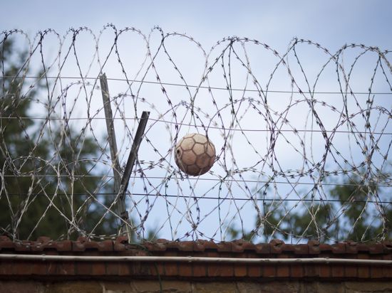 Ein Fußball hängt in der Justizvollzugsanstalt (JVA) im hessischen Butzbach im Stacheldraht auf der Gefängnismauer fest.