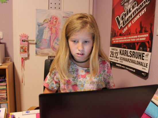 Mädchen sitzt vor dem Laptop