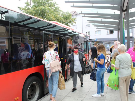Bildunterschrift: Warten auf den Bus: Die meisten Fahrgäste ziehen ihre Maske erst auf, wenn sie einsteigen.
