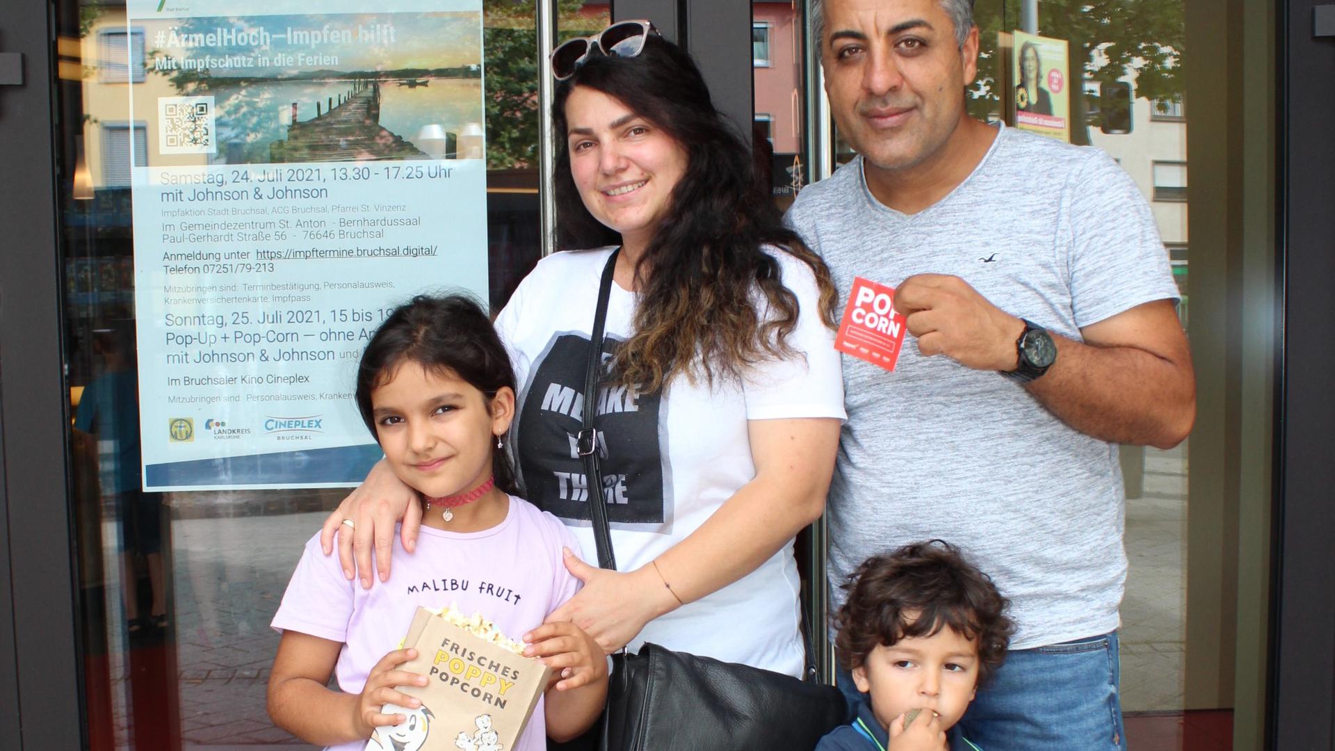 Für die Eltern gab es die Impfung, für die Kinder Popcorn. Familie Kemal Genc aus Forst mit Ehefrau Kudrec und den Kindern Elisa (7 J.), Liyam (3 J.) vor dem Kino. 