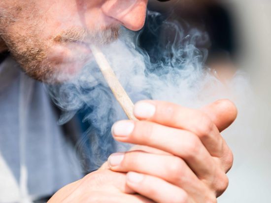 Ein Mann raucht bei der Auftaktkundgebung einer Demonstrationen für eine zügige Legalisierung von Cannabis, dem «Global Marijuana March 2022», am Brandenburger Tor einen Joint mit Medizinalcannabis. +++ dpa-Bildfunk +++