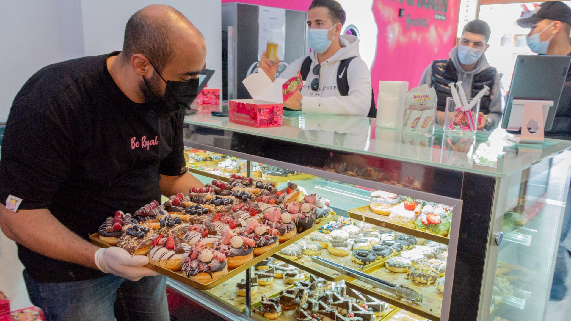 Magdi Safadi stellt eine Platte mit Donuts in seine Auslage im Donut-Laden in Bruchsal.