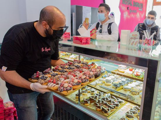 Magdi Safadi stellt eine Platte mit Donuts in seine Auslage im Donut-Laden in Bruchsal.