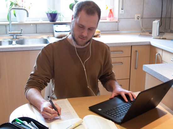Student Jannik Rößler verfolgt die Vorlesung vor dem Laptop in der Küche