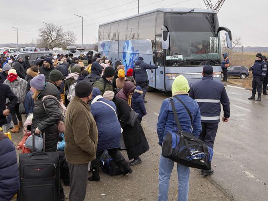 Geflüchtete warten auf einen Bus. Seit dem russischen Angriff auf die Ukraine sind nach UN-Angaben bereits 677 000 Menschen in Nachbarländer geflüchtet. +++ dpa-Bildfunk +++