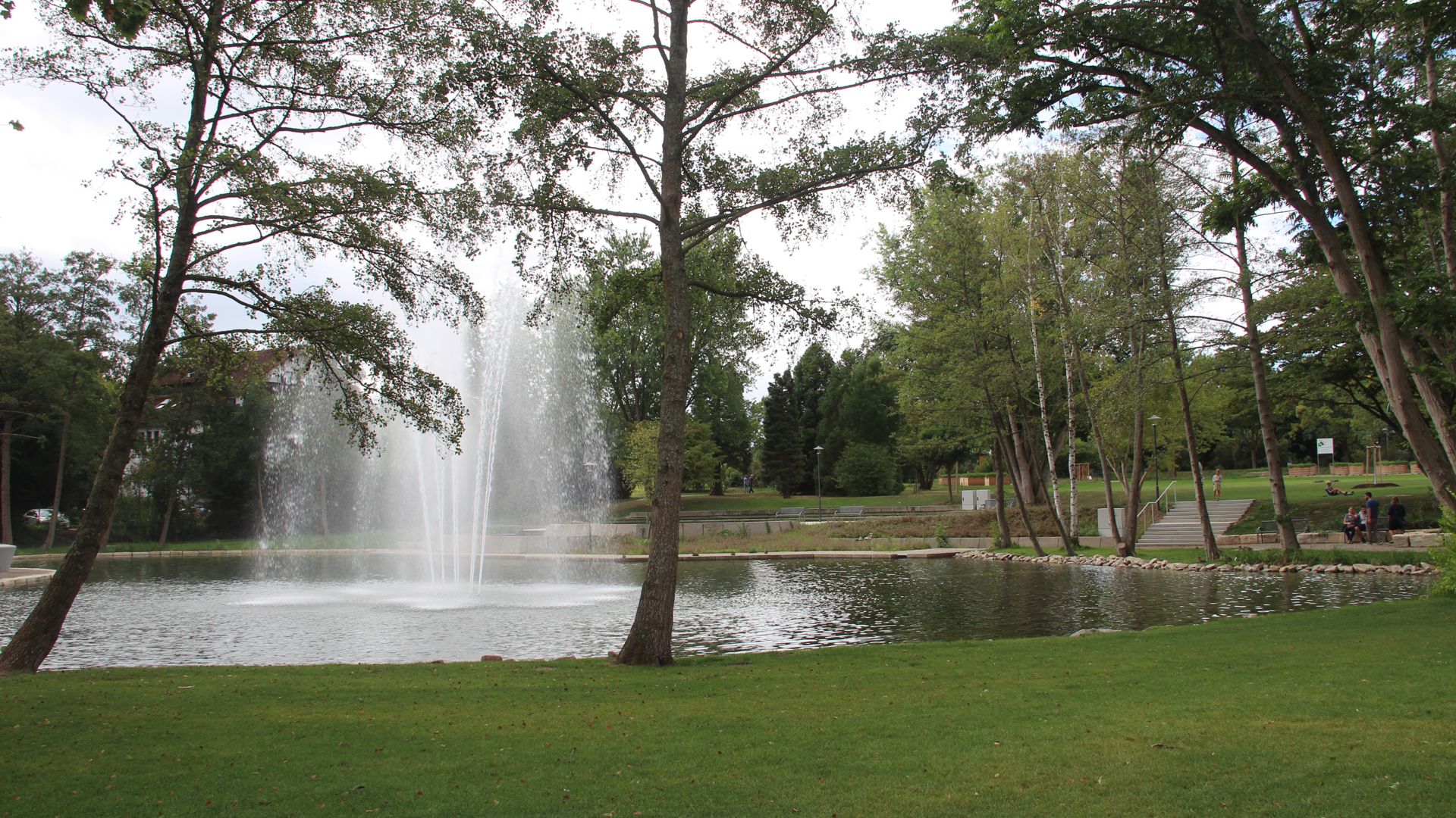 Wasserfontäne im Park, mit Bäumen