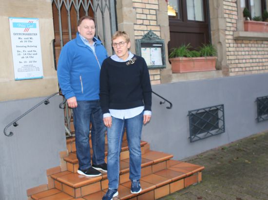 Ehepaar vor einem Haus mit vergitterter Tür