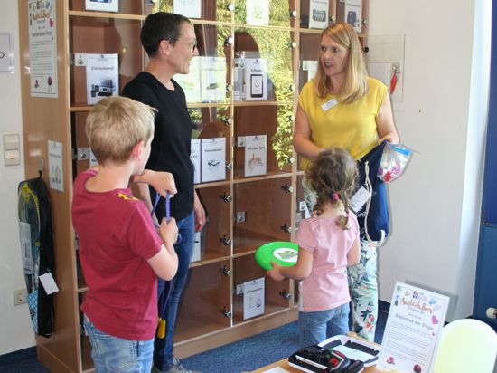 AusleihBar in Karlsdorf-Neuthard: Bibliotheksleiterin Jutta Walde (rechts) stellt Familie Brecht das neue Angebot vor. 