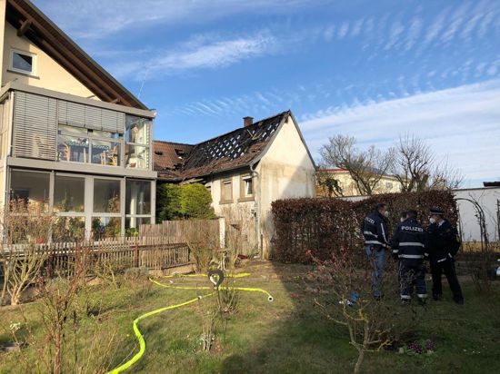 Einsatzkräfte begutachten ein Einfamilienhaus nach einem Brand im Landkreis Karlsruhe.