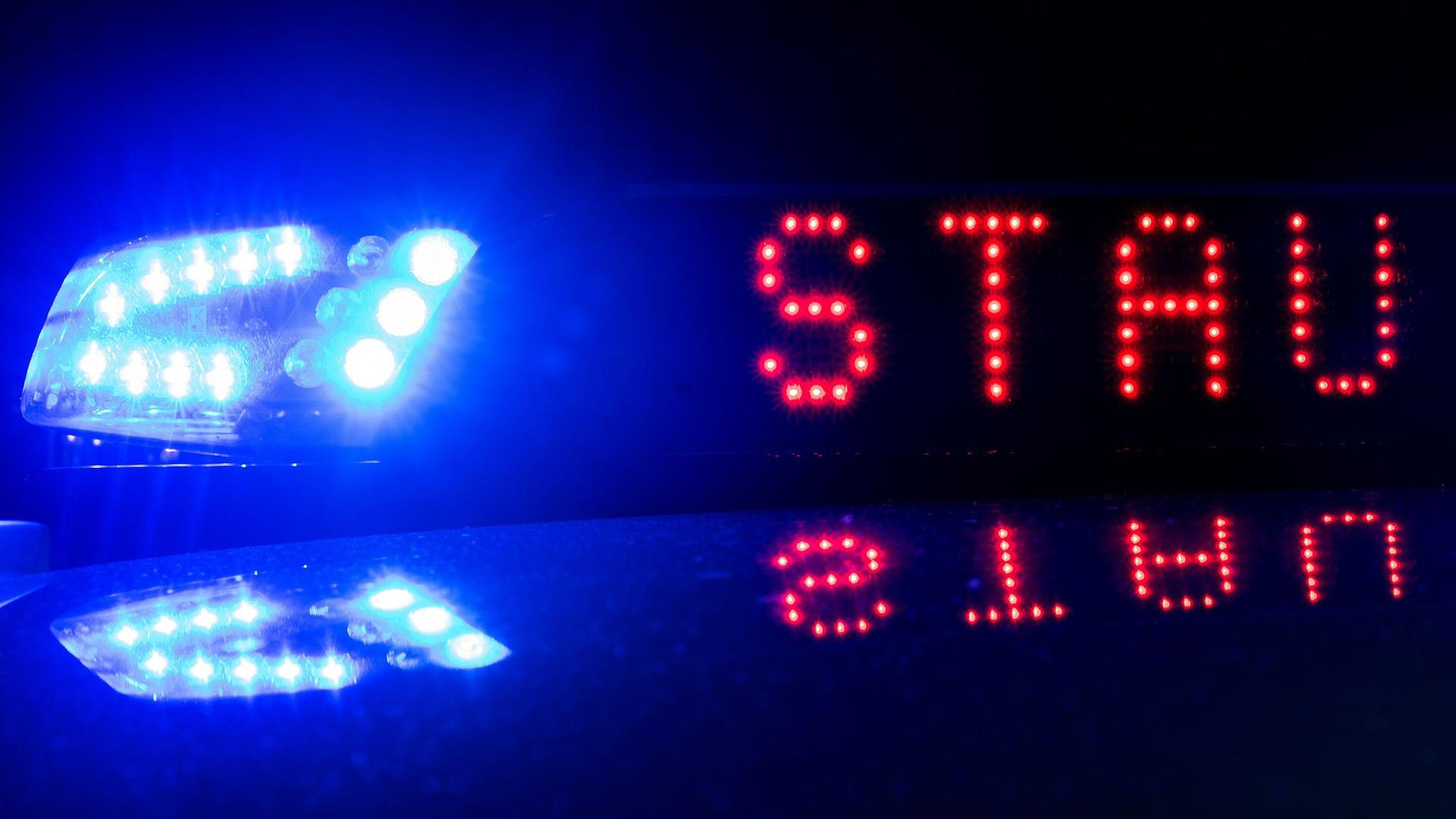 Das Blaulicht leuchtet bei einem Stau auf dem Dach eines Polizeifahrzeuges.