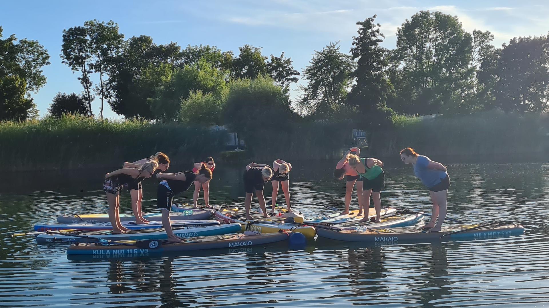 Frauen machen Yoga auf dem See