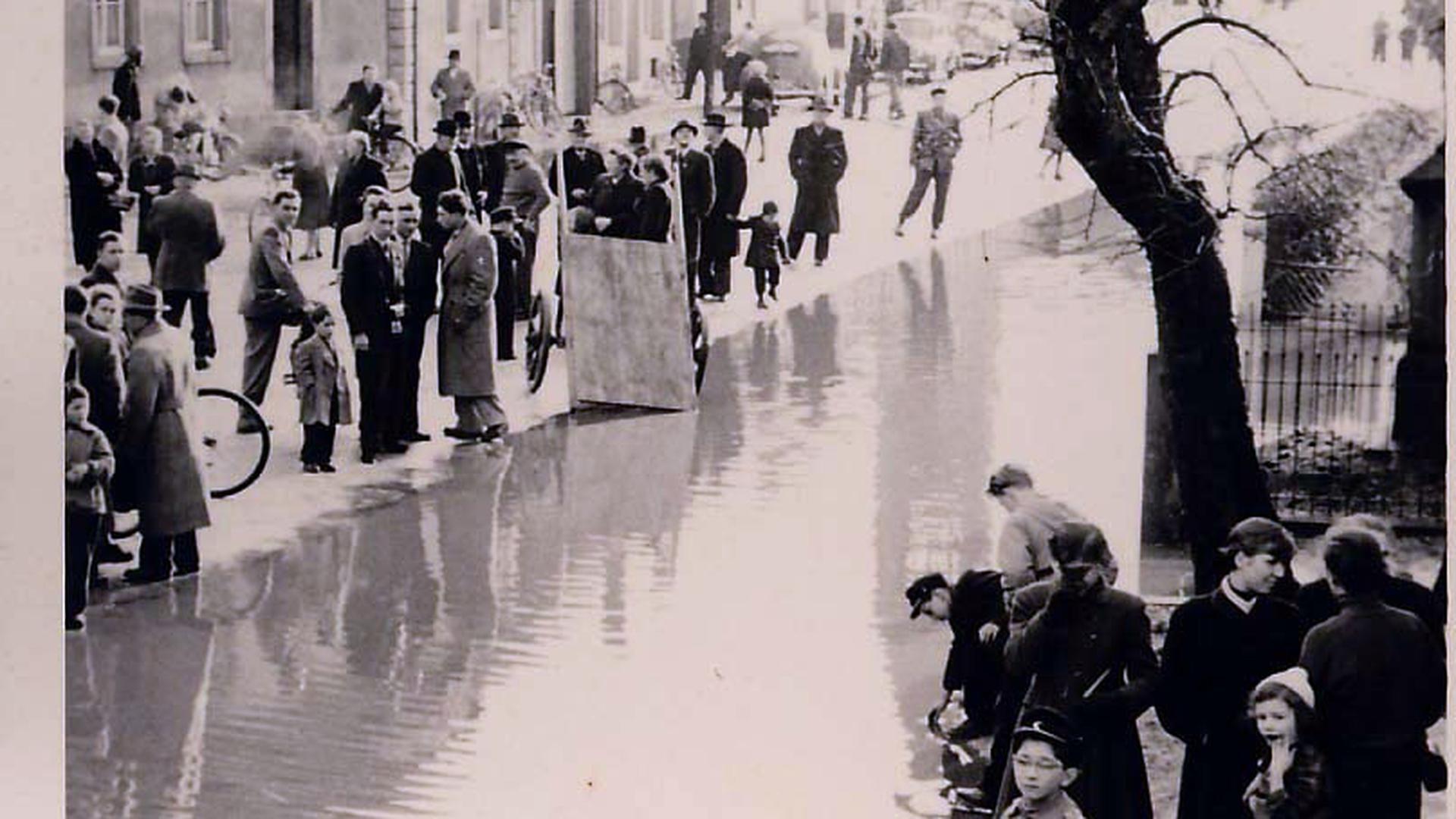 Altes schwarz-weiß Foto mit Menschen am Hochwasser.