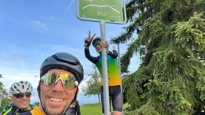 Radfahrer an Schild mit der Aufschrift Schindelberg 266 Meter