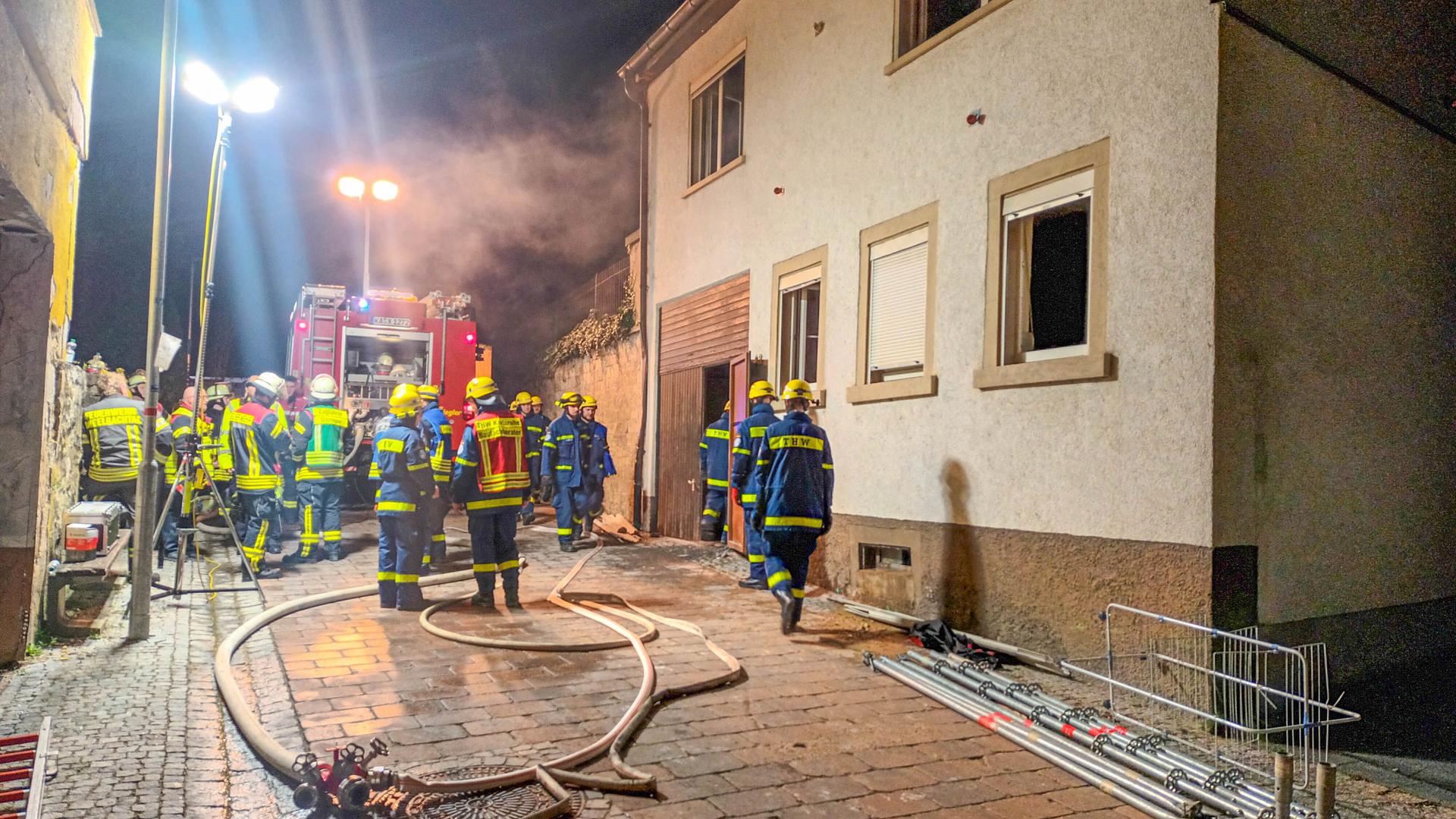 Feuerwehrleute vor einem brennenden Haus