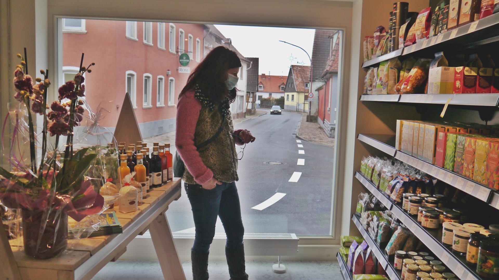 Eine Frau kauft in einem Geschäft ein, dem Bürgerhaus Löwen in Rheinsheim.