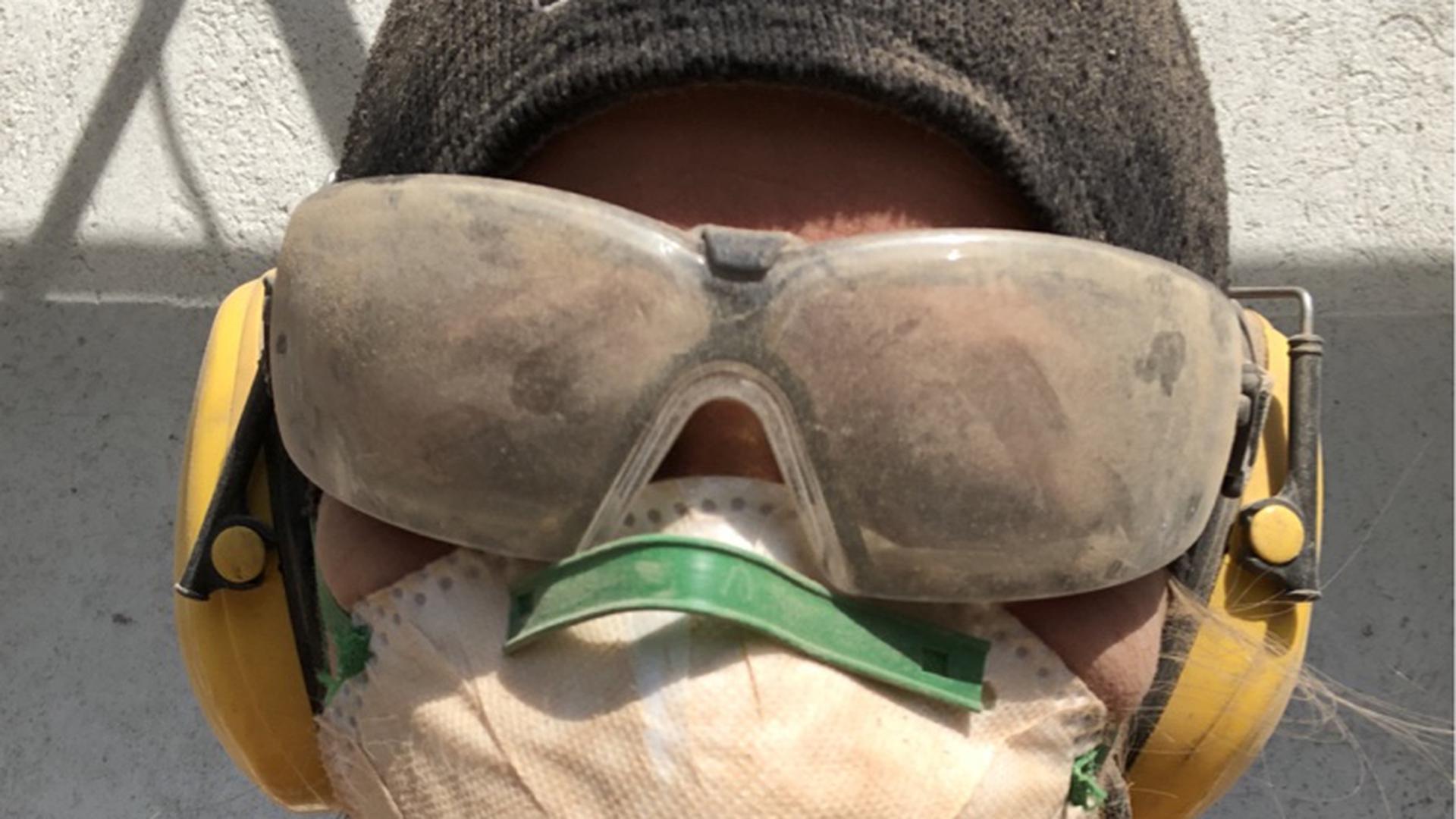 Randi Michels trägt beim Umbau eine verstaubte Schutzbrille und eine Atemschutzmaske