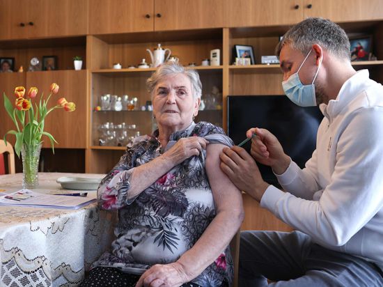 Der Hausarzt Robin John verabreicht der 84-jährigen Erika Dressler während eines Hausbesuchs die erste Impfung mit dem Corona-Impfstoff Comirnaty von Biontech/Pfizer. In Sachsen-Anhalt werden die niedergelassenen Ärzte in die Impfstrategie einbezogen. +++ dpa-Bildfunk +++