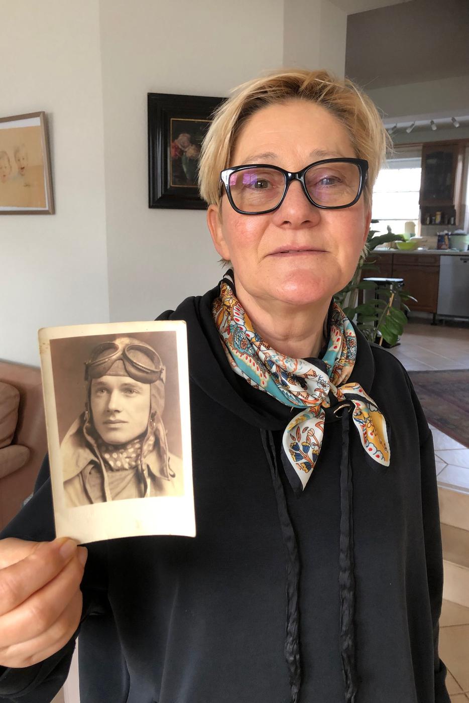 Frau mit Foto ihres Onkels in Fliegermontur aus dem 2. Weltkrieg