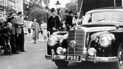 Schaulustige betrachten den Mercedes 300, mit dem Bundeskanzler Adenauer nach dem ersten Sitzungstag der Neunmächtekonferenz in London am zu einem Treffen mit Außenminister Eden fährt (Archivfoto vom 28.09.1954).