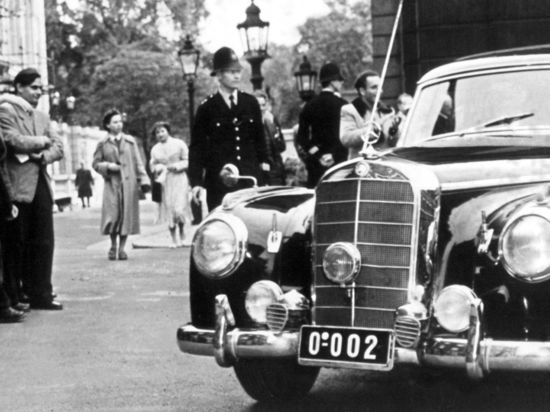 Schaulustige betrachten den Mercedes 300, mit dem Bundeskanzler Adenauer nach dem ersten Sitzungstag der Neunmächtekonferenz in London am zu einem Treffen mit Außenminister Eden fährt (Archivfoto vom 28.09.1954).