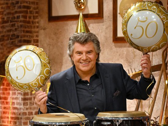 Der Sänger Andy Borg hält zwei Ballons mit der Aufschrift „50“ in der Hand. Am Sonntag läuft die 50. Folge der Sendung „Schlagerspaß mit Andy Borg“ im Fernsehen. 