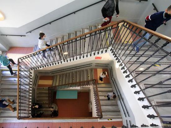 Schulkinder mit Gesichtsmasken gehen unter Beachtung der Abstandsregelungen eine Treppe in der wiedereröffneten Simone Veil Grundschule hoch. +++ dpa-Bildfunk +++