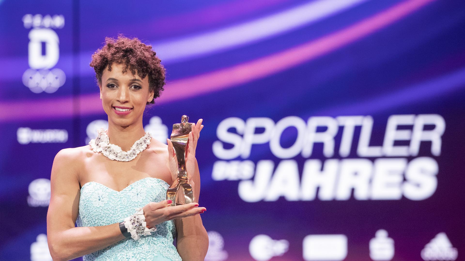 Leichtathletin Malaika Mihambo steht nach der Ehrung der «Sportler des Jahres 2020» auf der Bühne und hat die Trophäe in der Hand. Weitspringerin Mihambo wurde als Sportlerin des Jahres geehrt. +++ dpa-Bildfunk +++