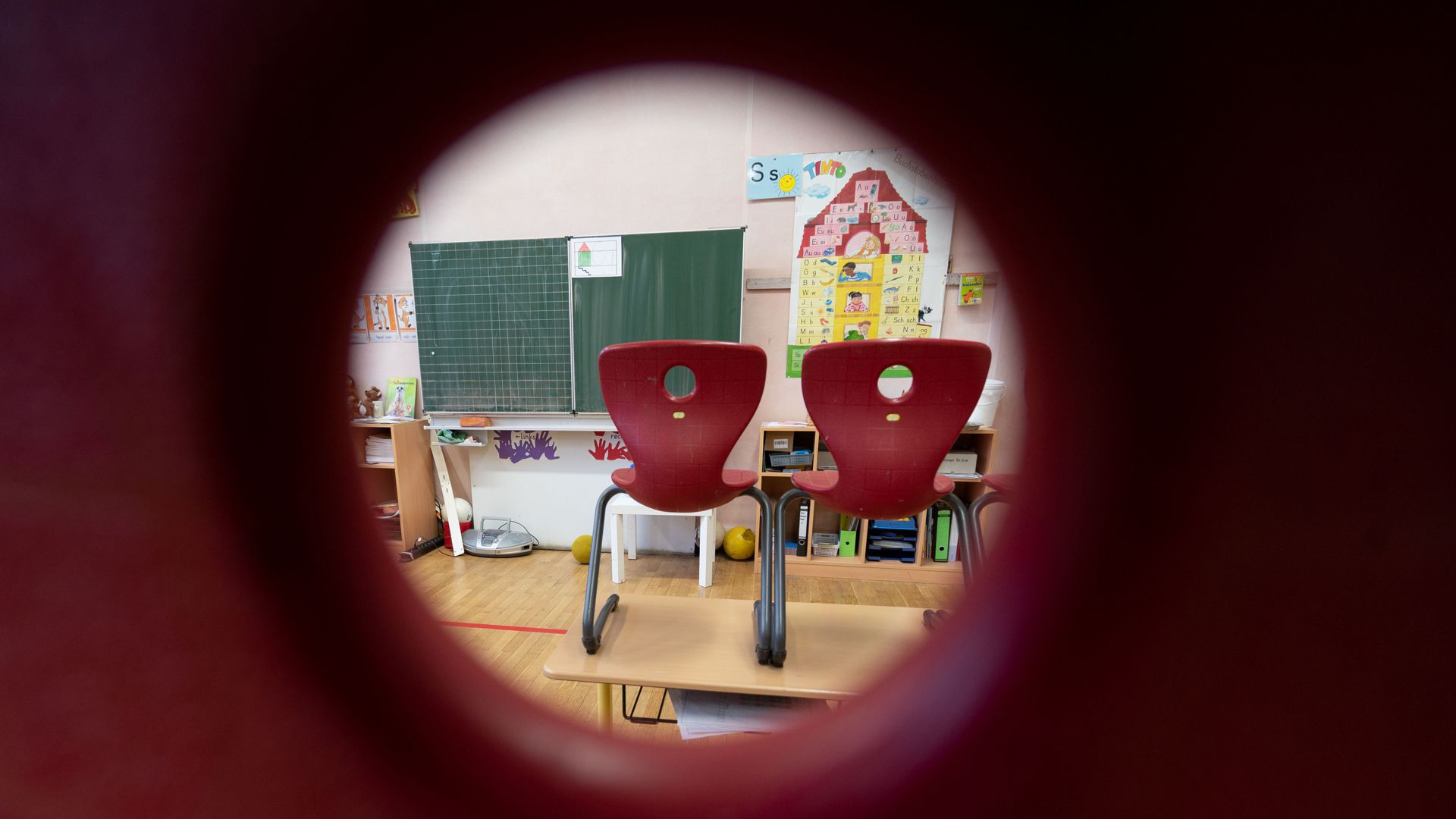 Stühle stehen in einem Klassenzimmer einer ersten Klasse  auf Tischen. (