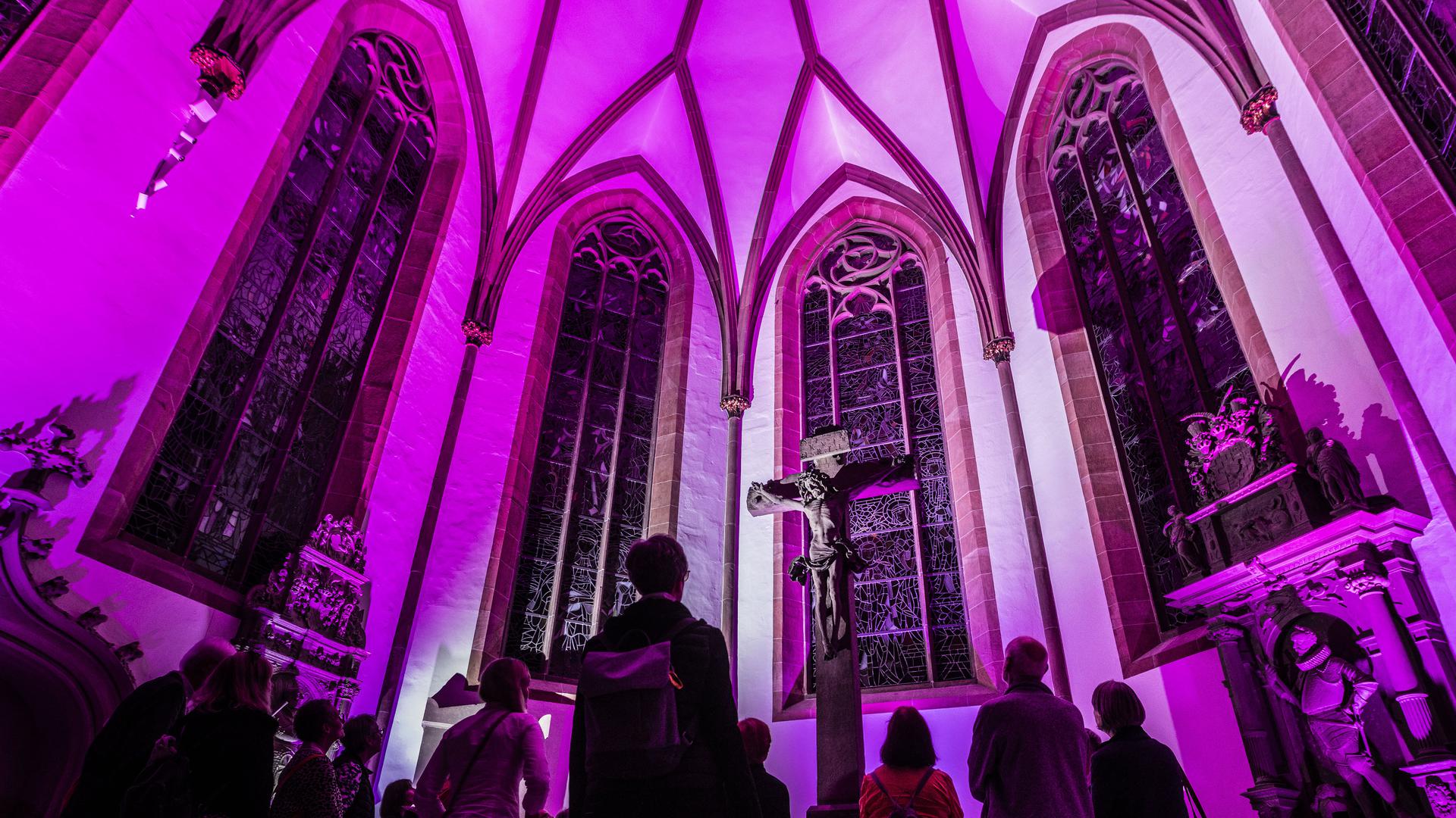 Besondere Stimmung: In lilafarbenes Licht getaucht, präsentiert sich das Kreuz im Chor der Stiftskirche. 