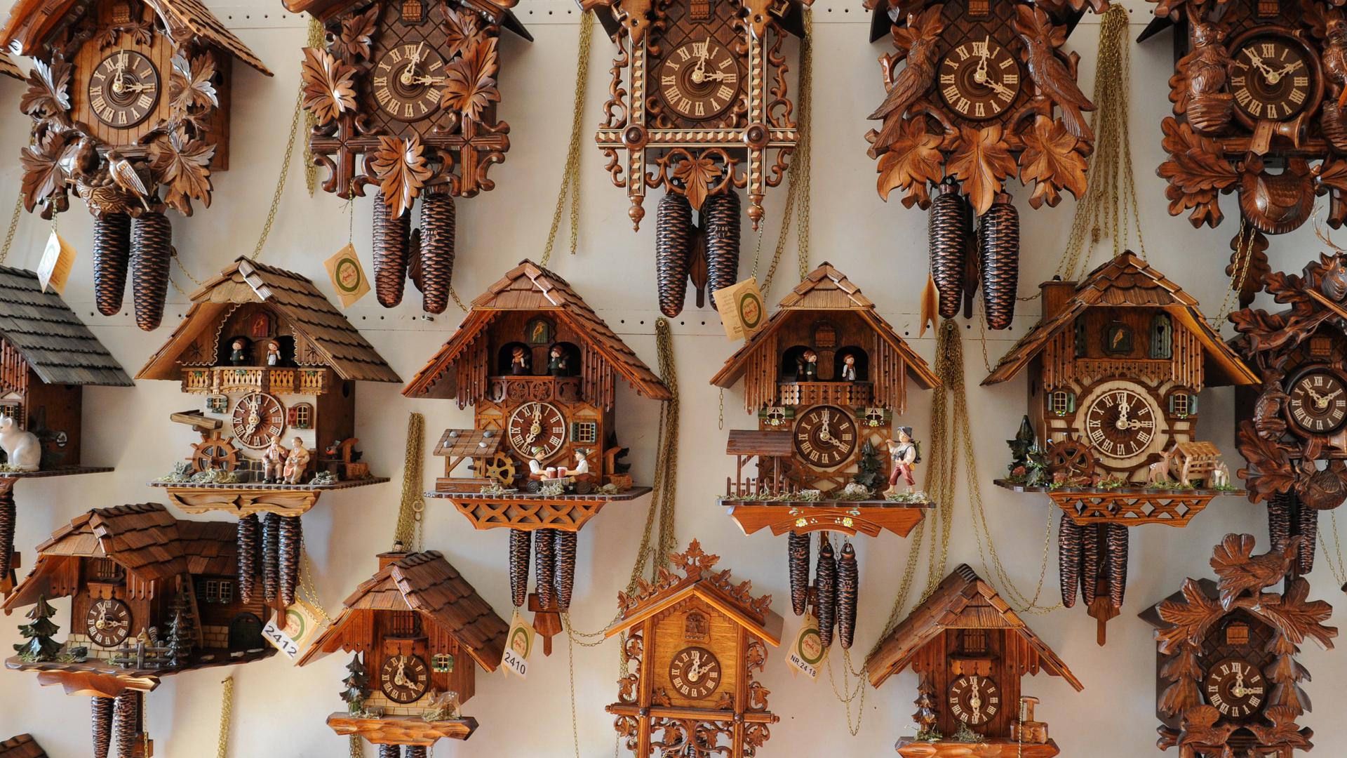 Kuckucksuhren hängen an einer Wand  in einer  Uhrenmanufaktur