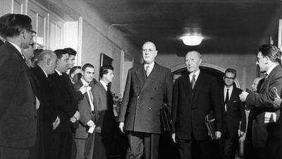 Der französische Staatspräsident Charles de Gaulle (Mitte) und der deutsche Bundeskanzler Konrad Adenauer (rechts neben de Gaulle) während einer Konferenz am 15. Februar 1962 in Baden-Baden. 