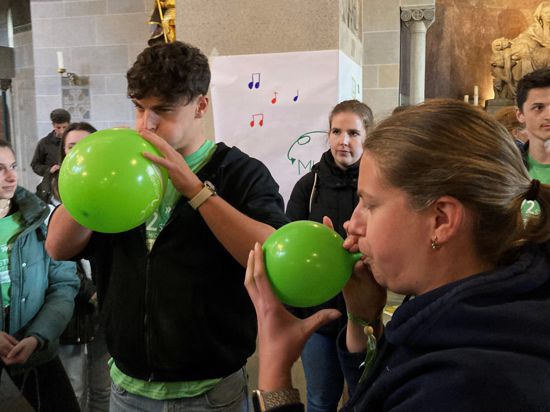 Teilnehmer der 72-Stunden-Aktion blasen Luftballons auf.