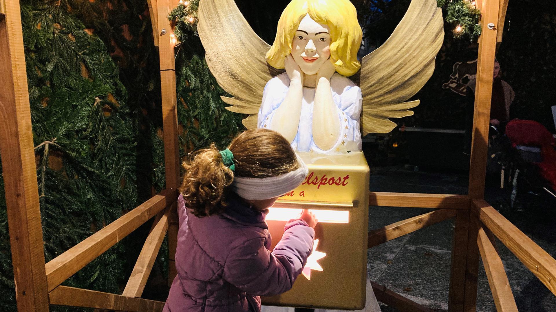 Post für das Christkind: Ein Mädchen wirft einen Brief in den Himmelspost-Briefkasten auf dem Christkindelsmarkt in Baden-Baden.