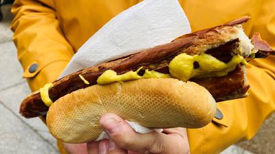 Der Klassiker: die Bratwurst, natürlich mit Senf. Eine Besucherin des Christkindelsmarktes in Baden-Baden isst das gegrillte Stück mit Genuss. 