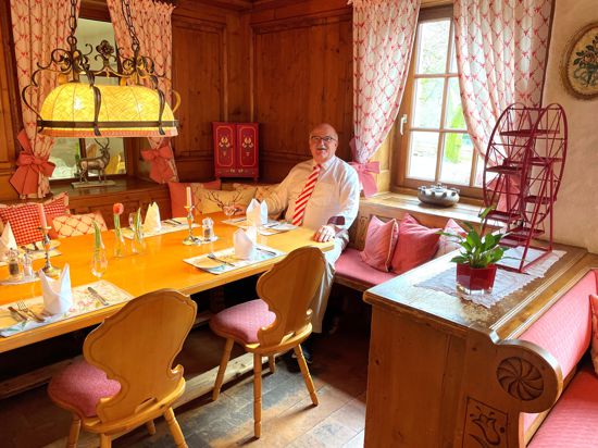Hans Schindler sitzt in seinem Restaurant an einem gedeckten Tisch. 
