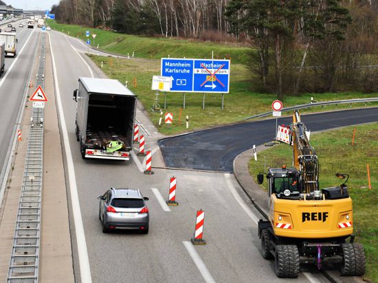 Autos fahren an der gesperrten Abfahrt der A5 bei Baden-Baden vorbei.