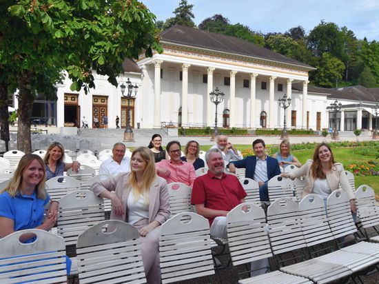 Redakteurinnen und Redakteure von BNN und BT sowie Assistenzen sitzen vor dem Baden-Badener Kurhaus auf weißen Stühlen.