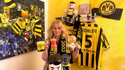 Ute Kretschmer-Risché steht in ihrem Büro mit unzähligen Fan-Utensilien des Fußballvereins Borussia Dortmund. 
