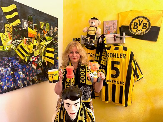 Ute Kretschmer-Risché steht in ihrem Büro mit unzähligen Fan-Utensilien des Fußballvereins Borussia Dortmund. 