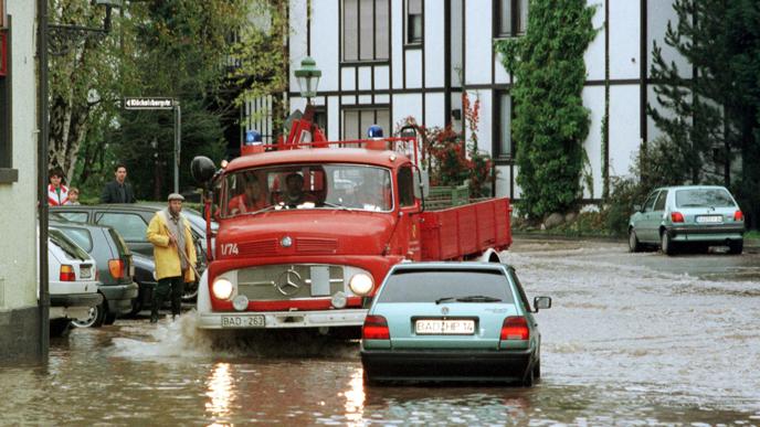 Ein Feuerwehrwagen fährt durchs Wasser.
