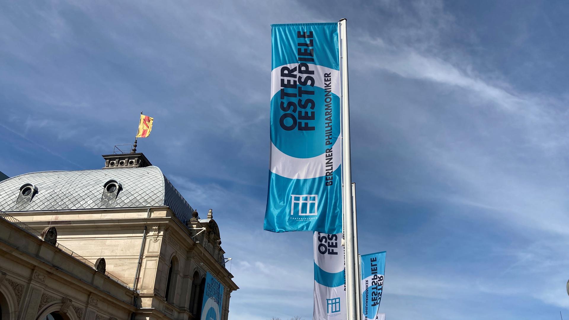 Vor dem Festspielhaus Baden-Baden wehen Flaggen in den Farben Blau und Weiß.