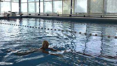 Eine Frau schwimmt in einem fast leeren Becken im Bertholdbad in Baden-Baden