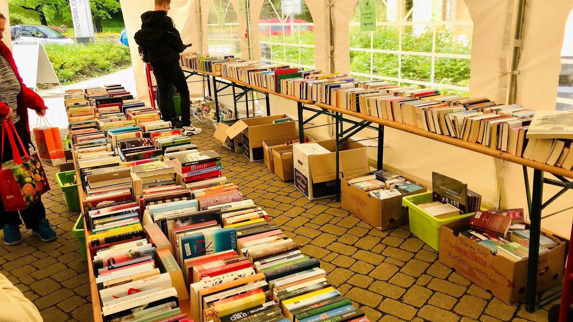 Menschen stöbern im Angebot beim Bücherflohmarkt an der Stadtbibliothek Baden-Baden. 